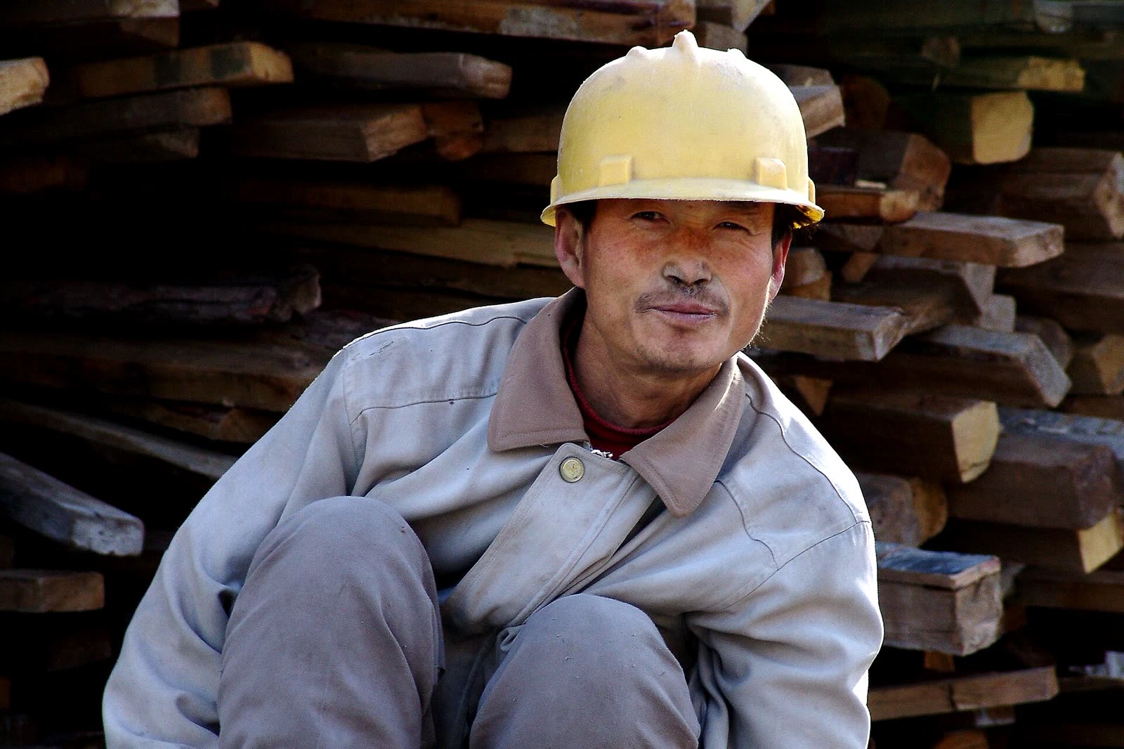 Mitarbeiter in Arbeitskleidung mit Schutzhelm, Beispielbild