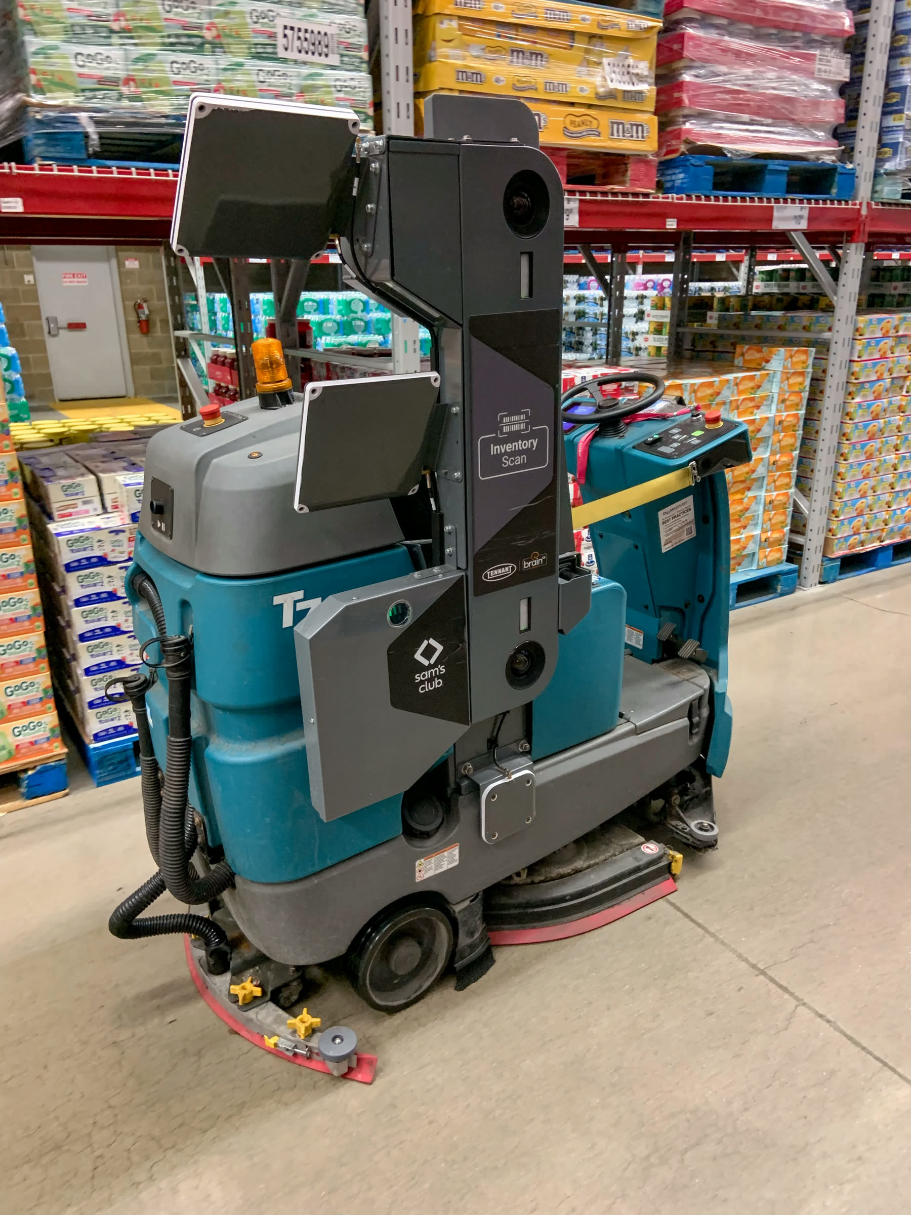 Reinigungskraft führt eine Scheuersaugmaschine über einen Verkaufsraumboden